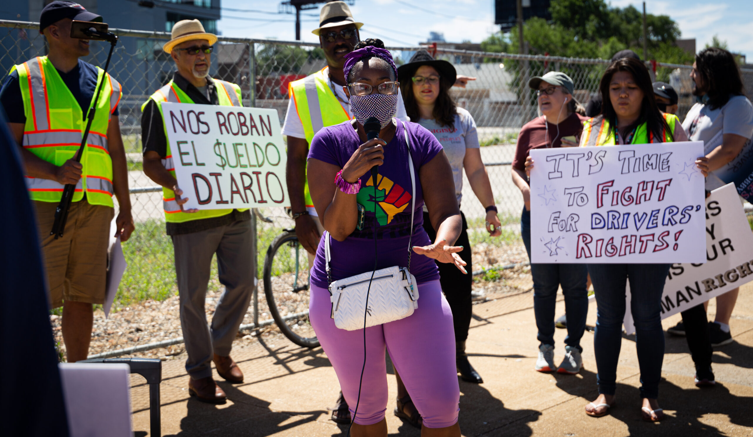 A group of people holding signs about corporate tax and protesting in front of a building.